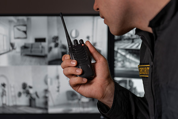 Guardia de seguridad con radio y pantallas de cámara